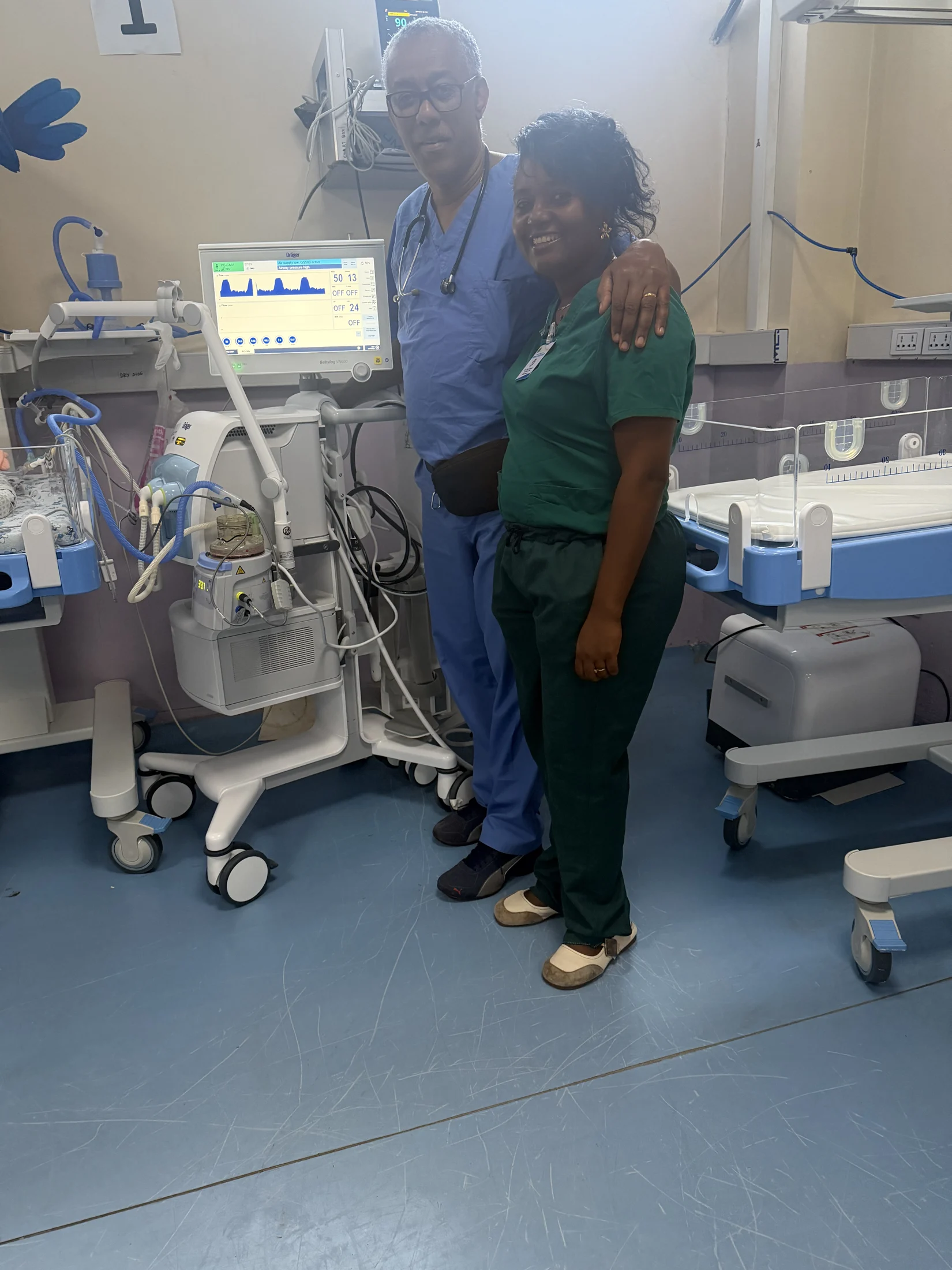 Two medical professionals beside newborn care equipment