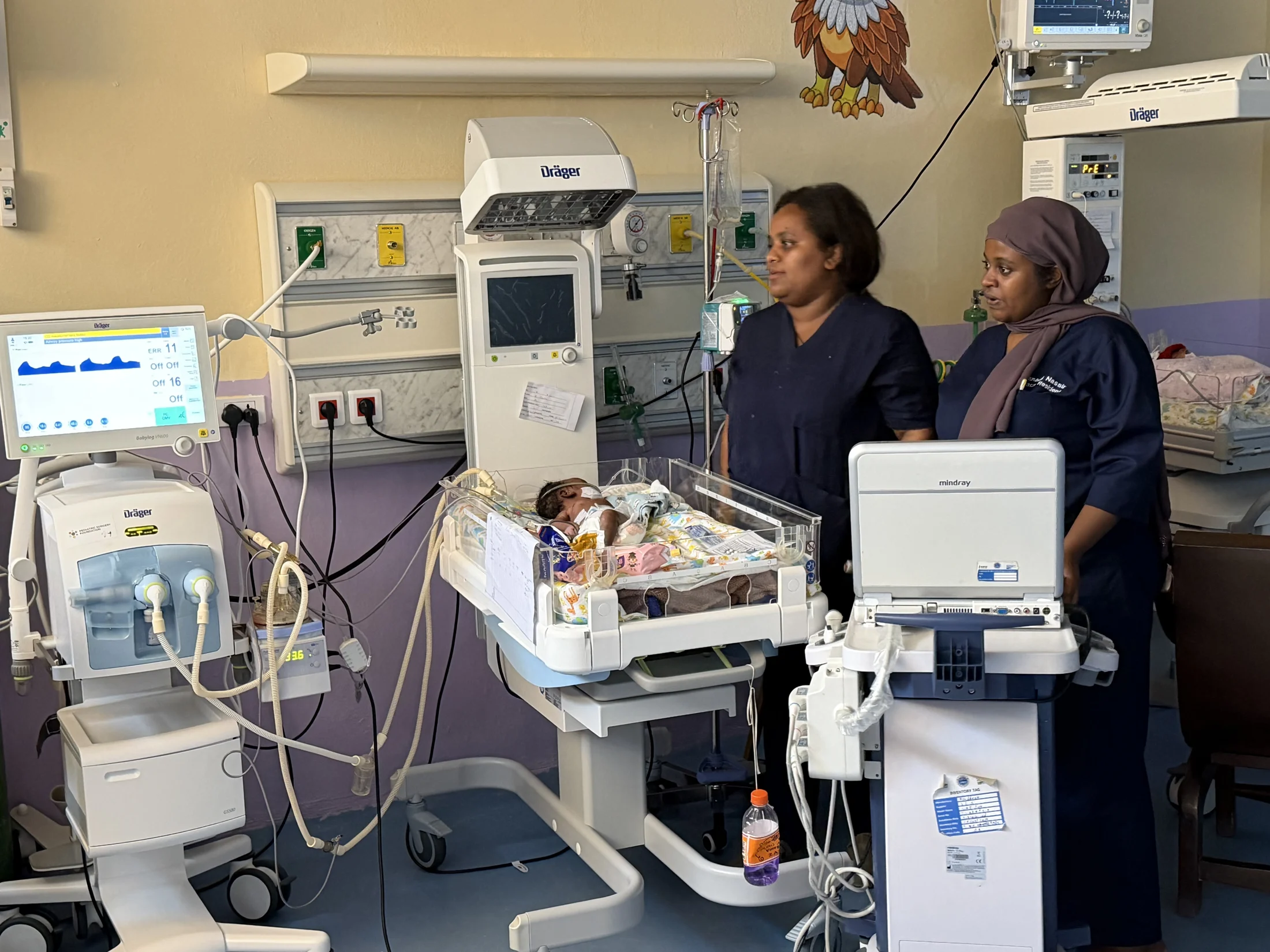 Medical professionals beside newborn care equipment