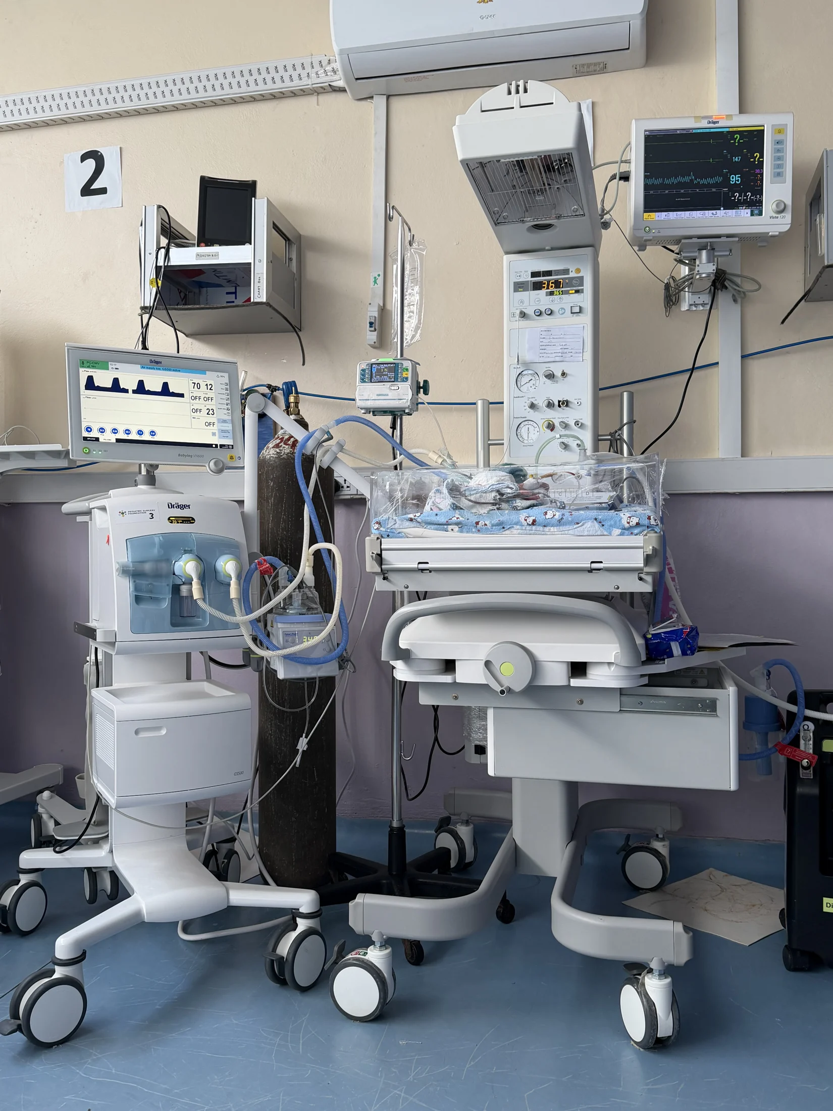 A neonatal care station with a warmer and monitors