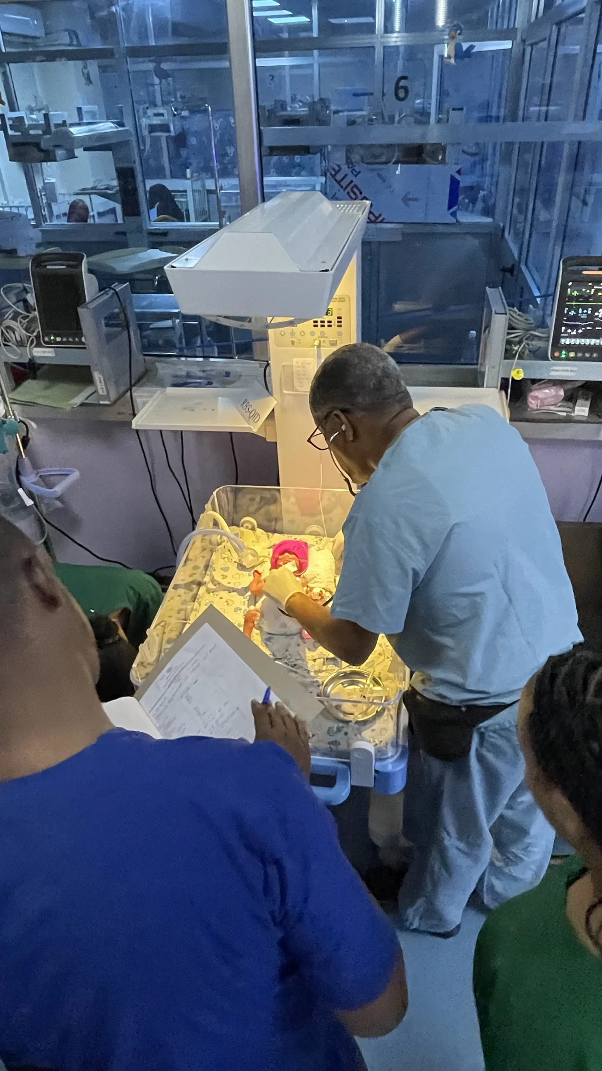 Medical professionals gathered around a newborn care station