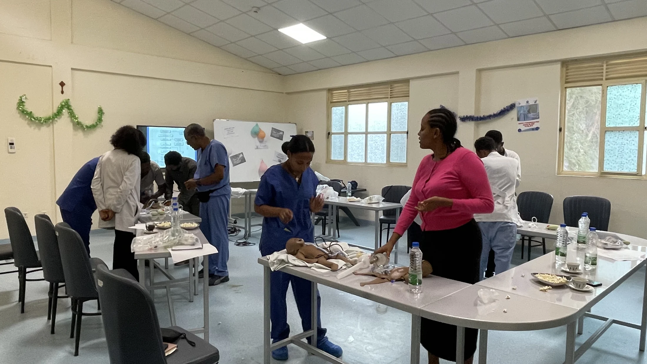 A group practicing neonatal care with training mannequins